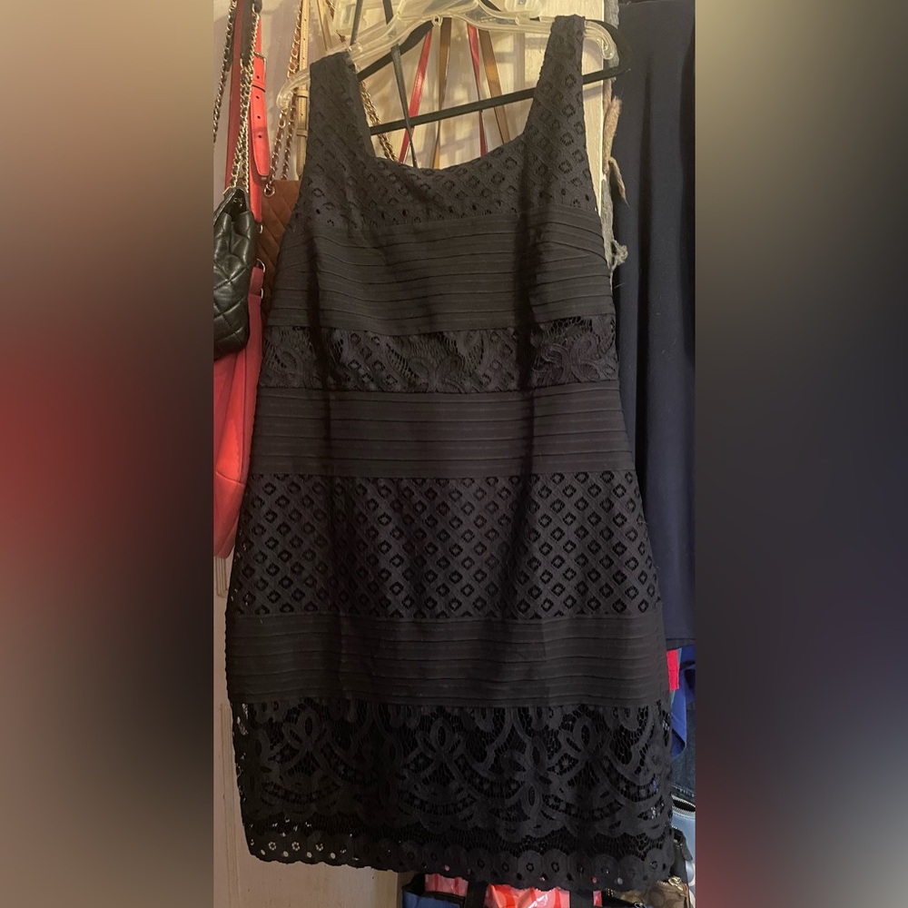 Sleeveless black straight dress with lace design.